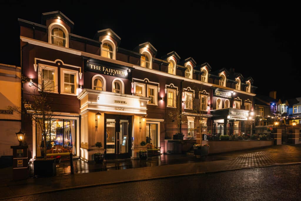 Night-time exterior view of the Fairview Hotel showing the full façade and lit windows.