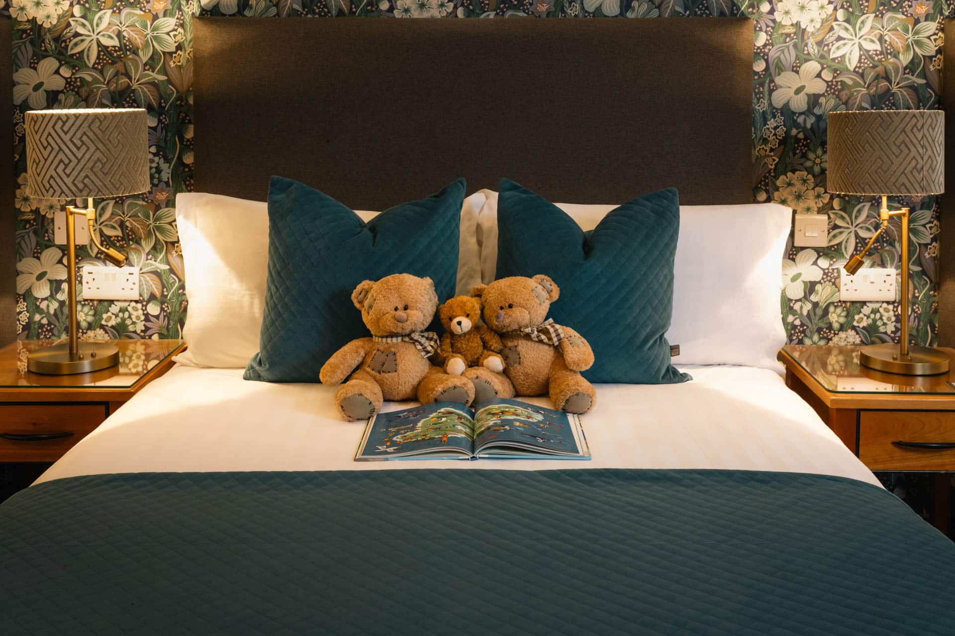 Family bedroom showing large bed with decorative cushions and warm ambient lighting.