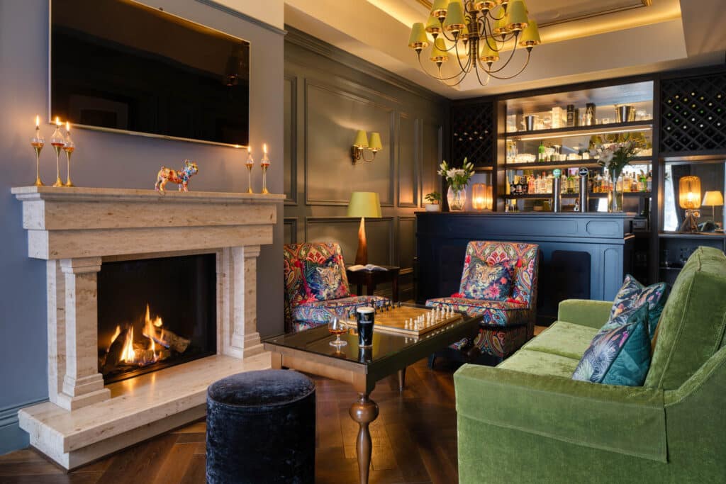 Lounge seating area with fireplace and patterned armchairs.