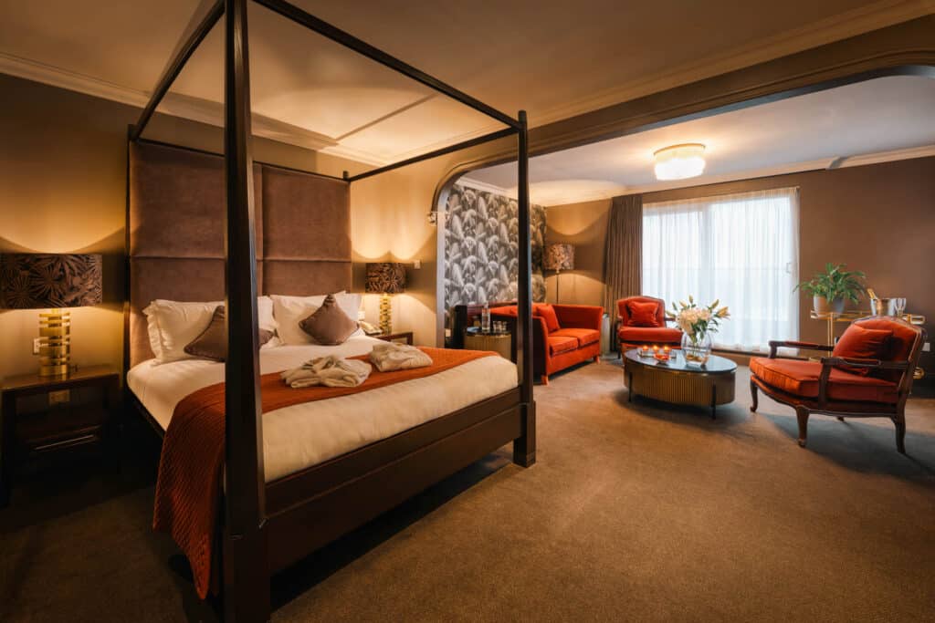 Penthouse bedroom with four-poster bed and seating area.