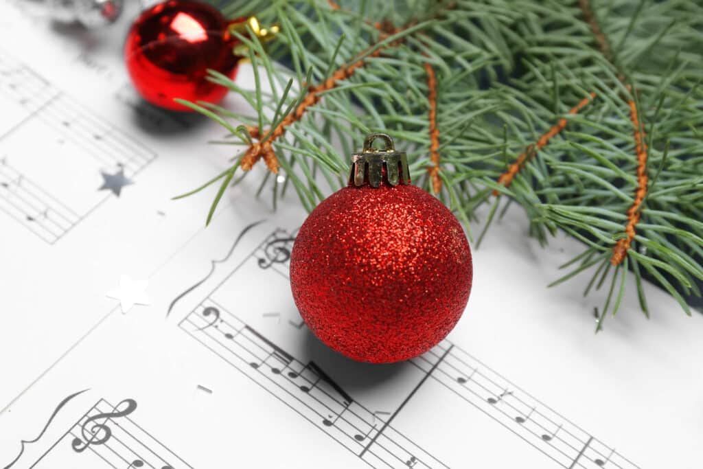 Christmas balls with fir branches on note sheets, closeup