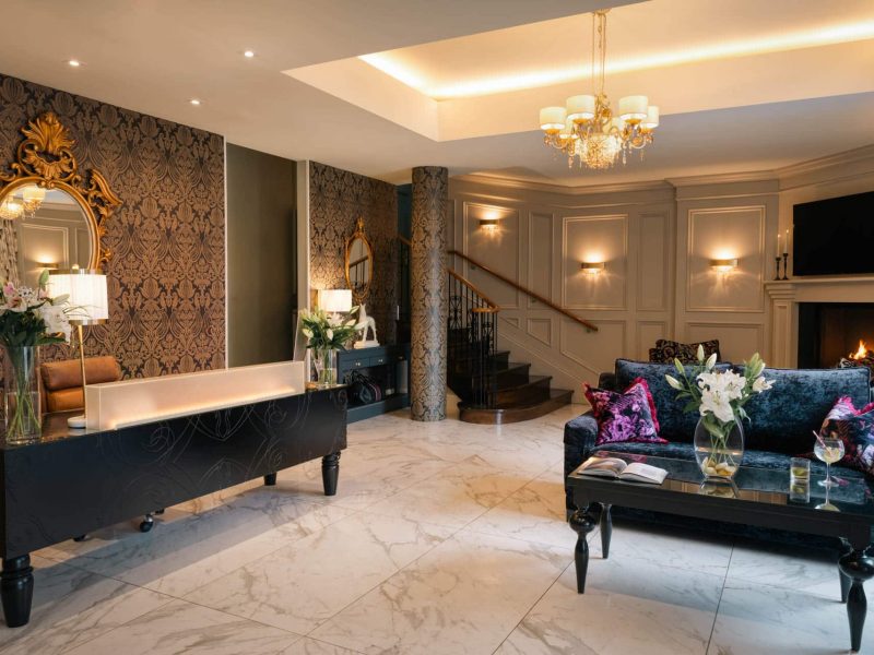View of hotel lobby with polished floors and decorative furnishings.