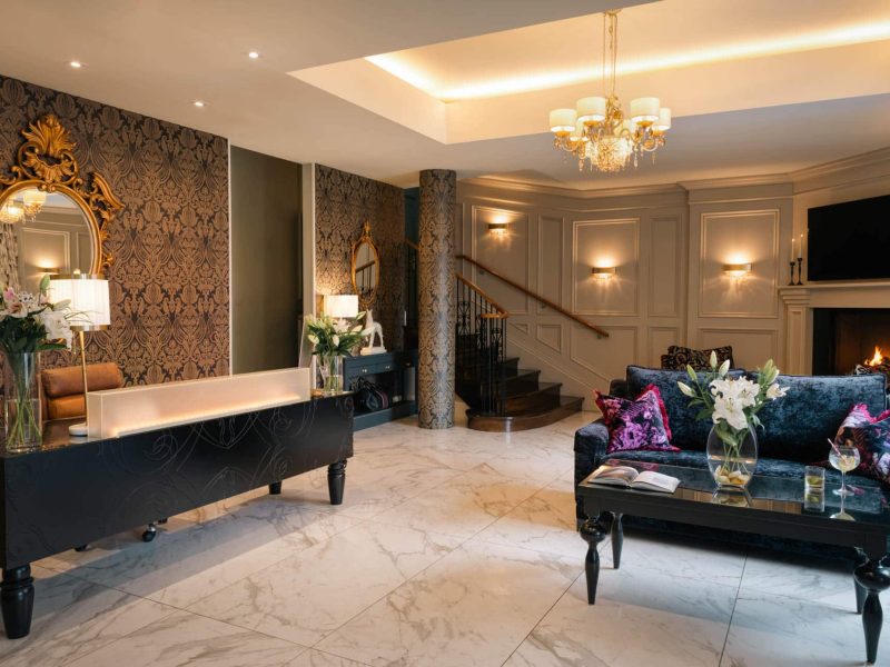 View of hotel lobby with polished floors and decorative furnishings.